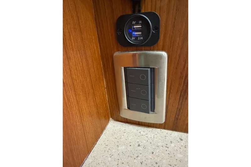 Slide: The Image of USB charging ports and light switches on a 2007 Tiara 43 yacht interior. - 14