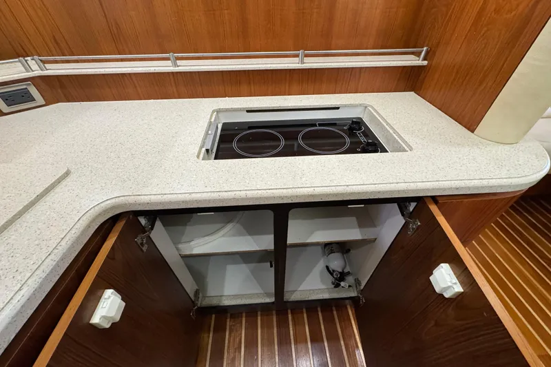 Slide: The Image of 2007 Tiara 43 yacht kitchen with electric stove and wooden cabinetry. - 17