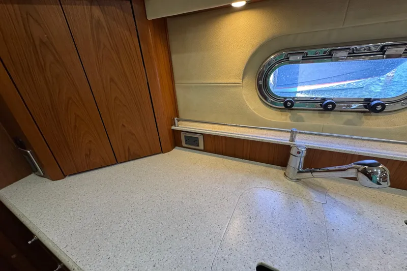 Slide: The Image of Tiara 43 yacht kitchen with wood cabinets, countertop, faucet, and porthole window, 2007 model. - 20