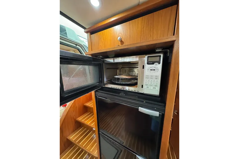 Slide: The Image of 2007 Tiara 43 yacht kitchen with microwave and refrigerator, wooden cabinetry. - 25