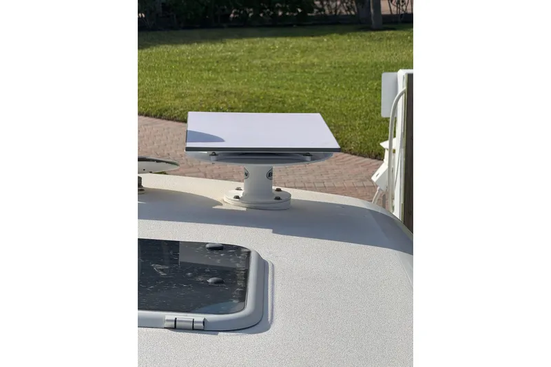 Slide: The Image of Satellite dish mounted on a 2007 Tiara 43 boat, with a grassy background. - 28