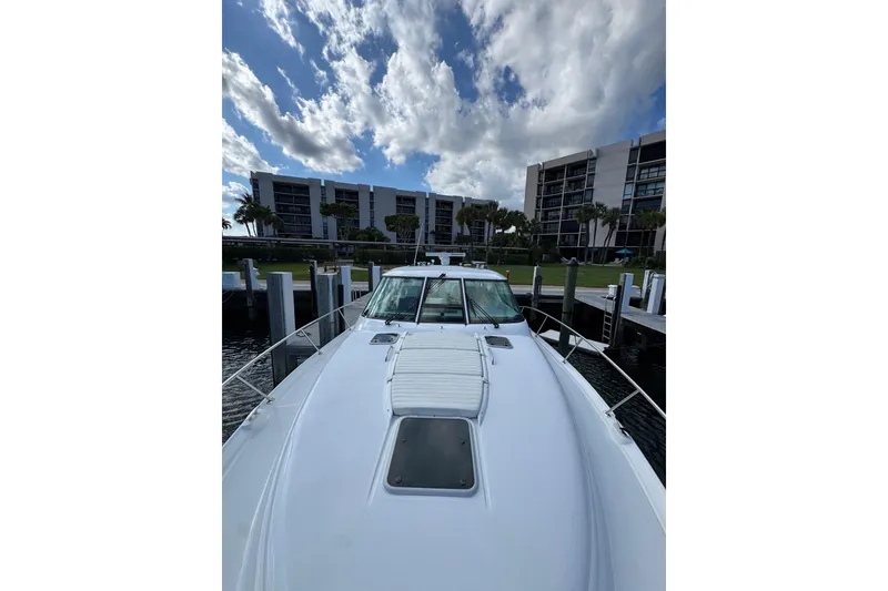 Slide: The Image of 2007 Tiara 43 yacht docked with modern buildings and cloudy sky in background. - 29
