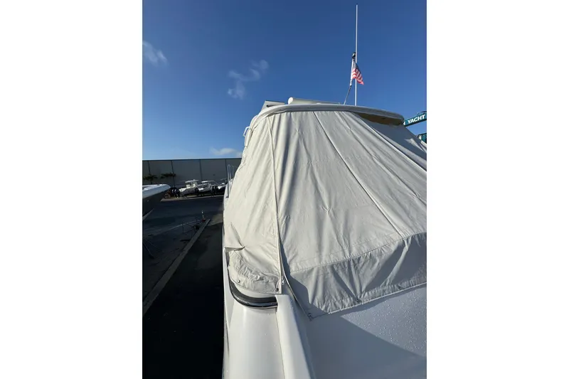 Slide: The Image of Covered 2007 Tiara 43 yacht with American flag, docked under clear blue sky. - 33
