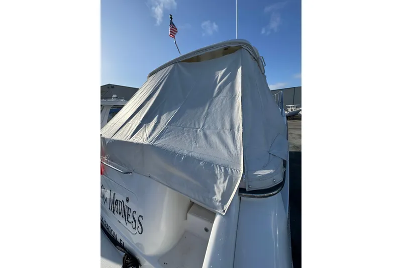 Slide: The Image of 2007 Tiara 43 yacht with cover, docked under clear blue sky. - 34