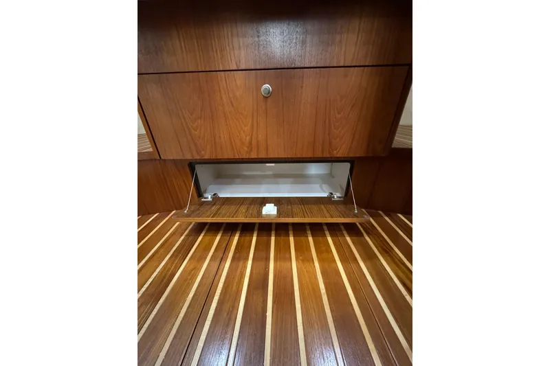Slide: The Image of Wooden interior storage compartment in 2007 Tiara 43 yacht, featuring open cabinet and striped flooring. - 8