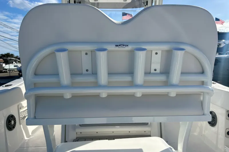 Slide: The Image of 2026 Sea Fox 268 Commander boat rod holders and seating, with American flags in the background. - 25