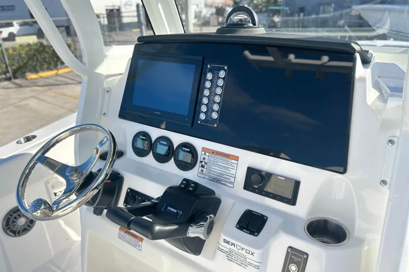 Slide: The Image of 2026 Sea Fox 268 Commander boat dashboard with steering wheel and navigation controls. - 3