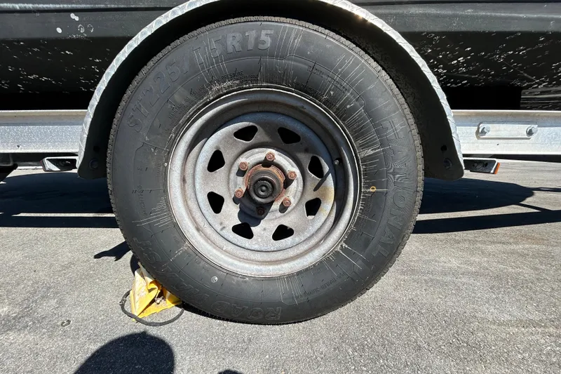 Slide: The Image of Trailer wheel of 2020 Clearwater 2000 Center Console boat on pavement. - 69