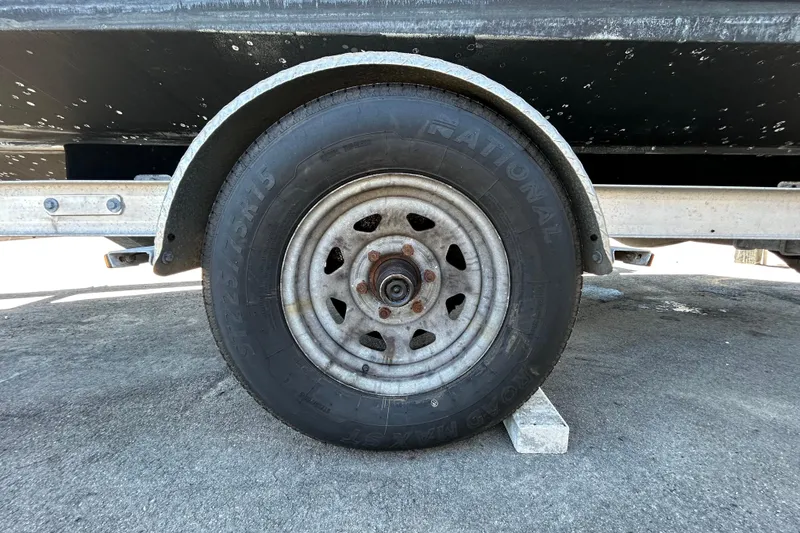 Slide: The Image of Trailer wheel of a 2020 Clearwater 2000 Center Console boat on pavement. - 70