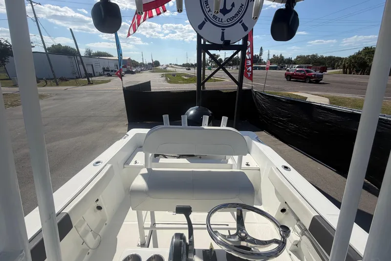 Slide: The Image of 2020 Clearwater 2000 Center Console boat interior with steering wheel and seating, parked outdoors. - 86