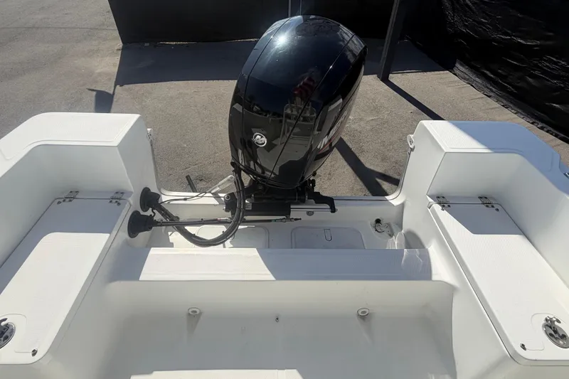 Slide: The Image of 2020 Clearwater 2000 Center Console boat with powerful outboard motor, rear seating, and storage compartments. - 89