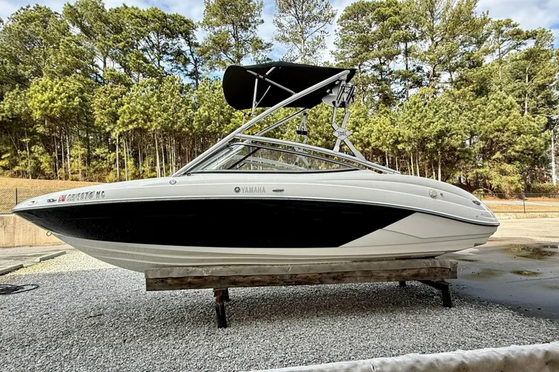 The Image of 2010 Yamaha Boats 212X on display, surrounded by trees and gravel. - 0