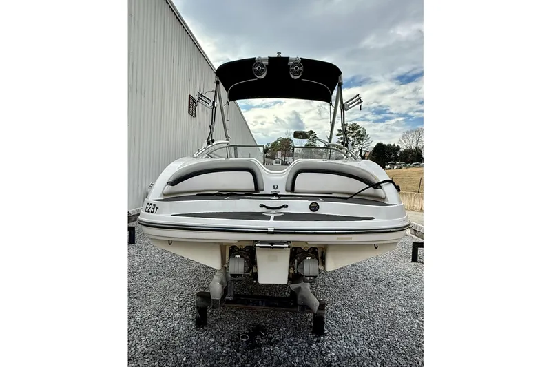 Slide: The Image of 2010 Yamaha Boats 212X, rear view, parked on gravel, under cloudy sky. - 12