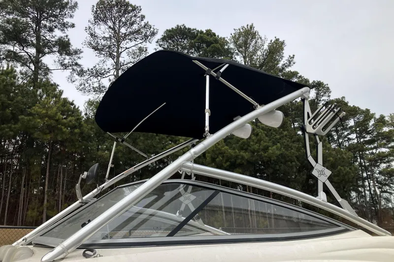 Slide: The Image of 2010 Yamaha Boats 212X with wakeboard tower and canopy, set against a forest backdrop. - 3