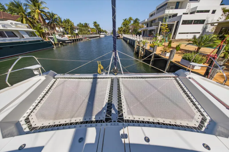 Slide: The Image of 2021 Leopard 50 catamaran on a sunny canal with palm trees and modern homes. - 101