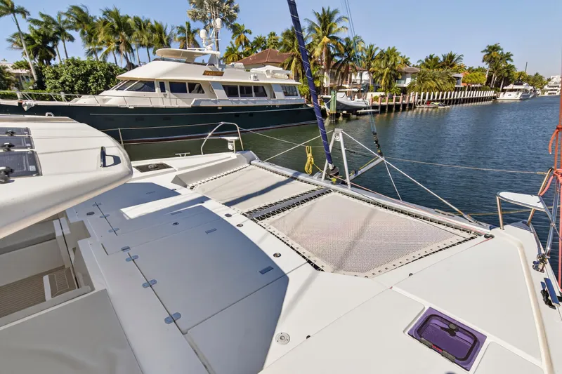 Slide: The Image of Leopard 50 catamaran docked in a sunny marina, surrounded by palm trees and yachts. - 102