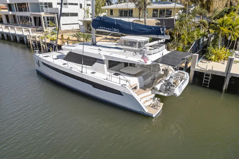 Slide: The Image of 2021 Leopard 50 yacht docked by waterfront homes, featuring sleek design and spacious deck. - 121