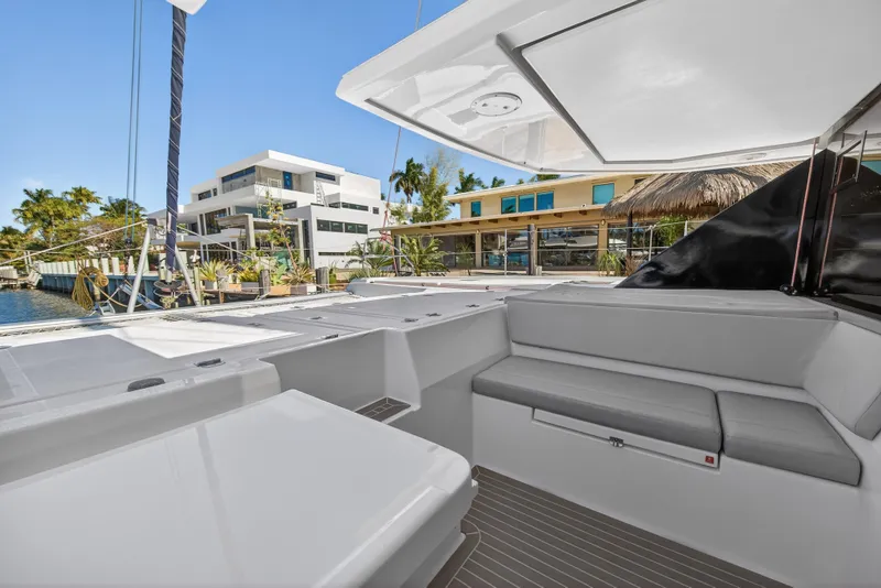Slide: The Image of 2021 Leopard 50 yacht deck with modern seating, docked near waterfront homes. - 49