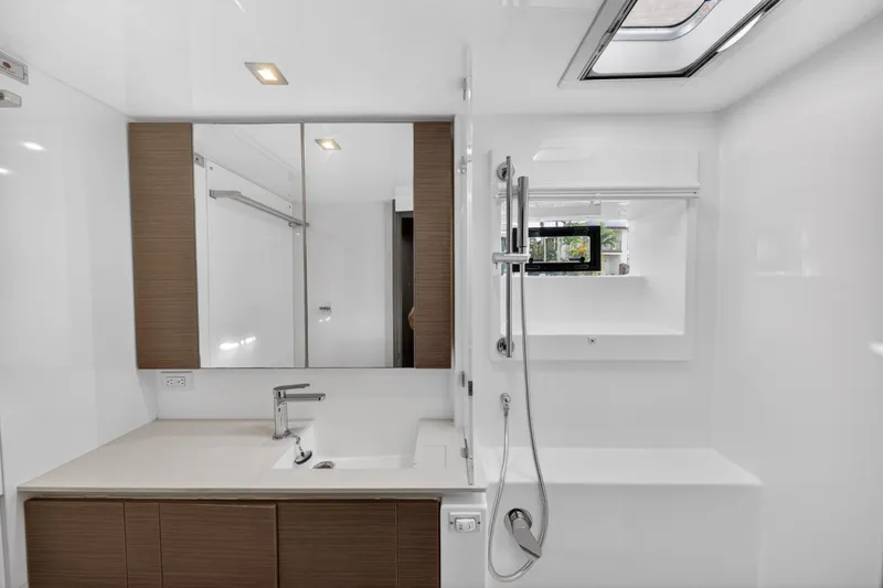 Slide: The Image of Modern yacht bathroom with sleek fixtures, mirror, and shower in a 2022 Leopard 50 model. - 129