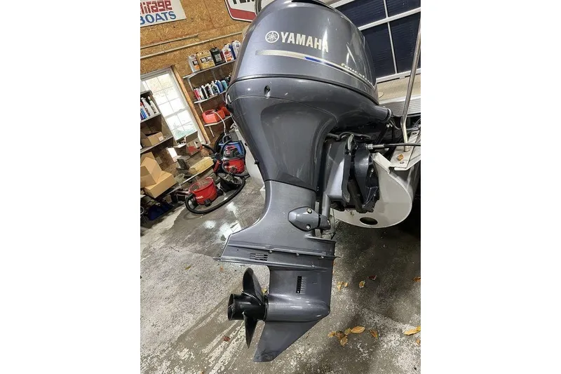 Slide: The Image of 2018 Bennington 23 SLX with Yamaha outboard motor in a garage setting. - 14