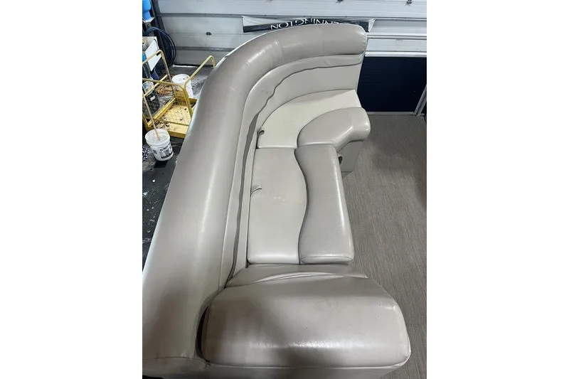 Slide: The Image of 2018 Bennington 23 SLX boat interior with beige seating in a workshop setting. - 3