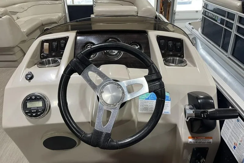 Slide: The Image of Steering console of a 2018 Bennington 23 SLX pontoon boat with controls and cup holders. - 8