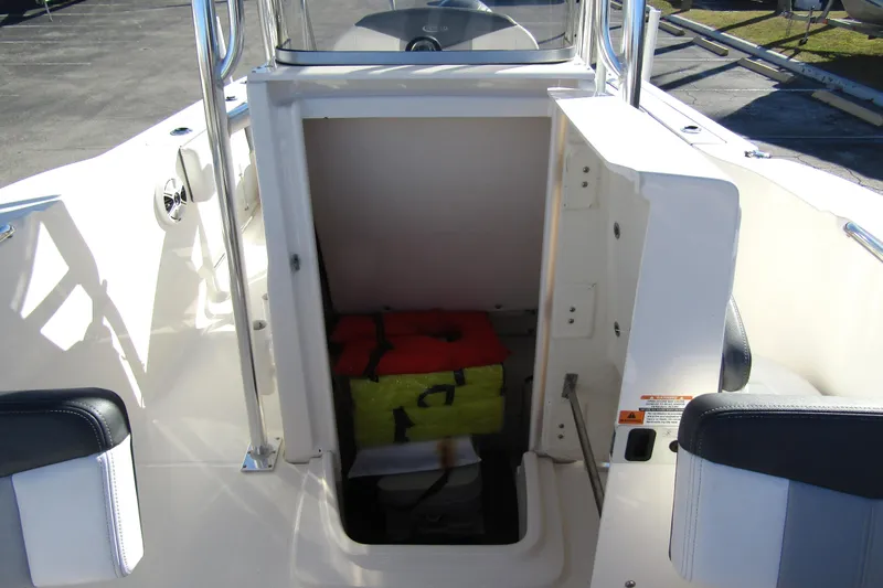Slide: The Image of 2019 Robalo R202 Explorer boat storage compartment with life jackets inside. - 13