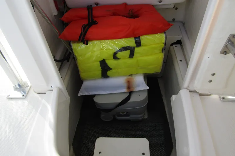 Slide: The Image of 2019 Robalo R202 Explorer boat storage with life jackets and portable toilet. - 14