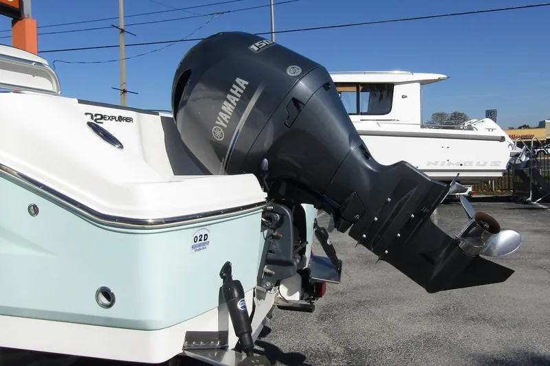 Slide: The Image of 2019 Robalo R202 Explorer with Yamaha outboard motor, parked on pavement. - 2