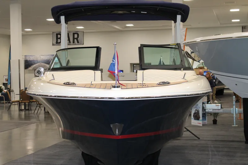 Slide: The Image of 2026 Chris-Craft Sportster 25 boat displayed indoors, showcasing sleek design and modern features. - 17