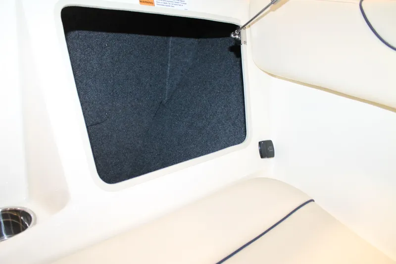 Slide: The Image of 2026 Chris-Craft Sportster 25 interior storage compartment with cushioned seating. - 43