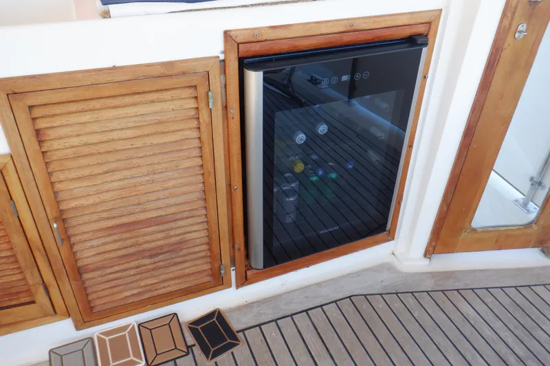 Slide: The Image of 1990 Marine Trader 47 Tradewinds yacht with built-in mini fridge and wooden cabinetry. - 10