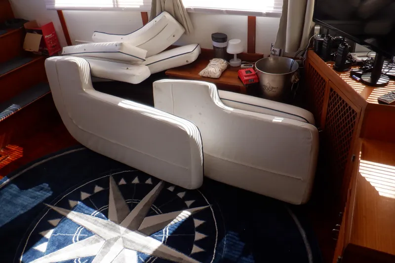 Slide: The Image of Interior of 1990 Marine Trader 47 Tradewinds with white cushions and nautical decor. - 19