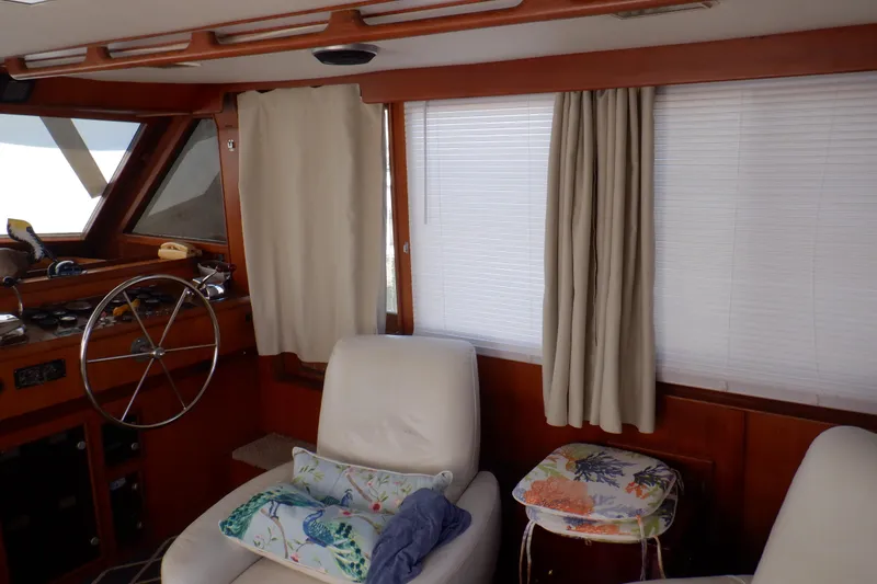 Slide: The Image of 1990 Marine Trader 47 Tradewinds yacht interior with helm, seating, and curtains. - 22