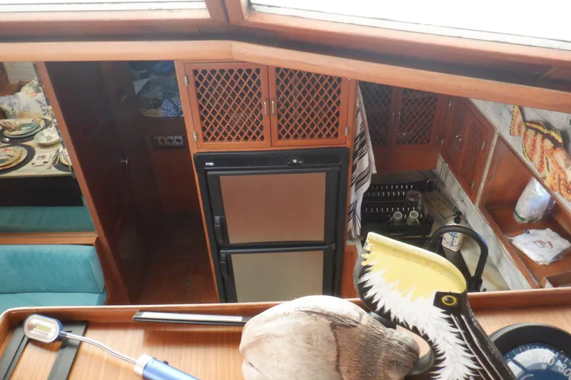 Slide: The Image of Interior of 1990 Marine Trader 47 Tradewinds yacht, featuring kitchen and dining area. - 26