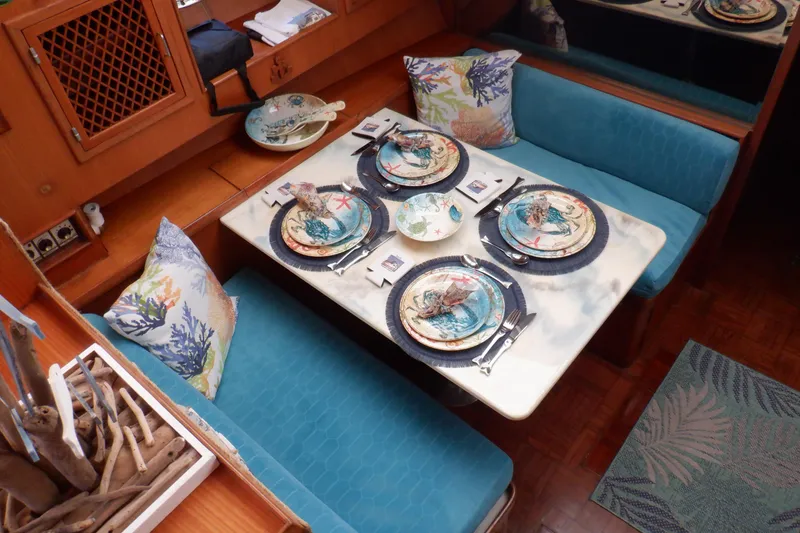 Slide: The Image of Dining area in 1990 Marine Trader 47 Tradewinds yacht with nautical-themed table setting. - 28