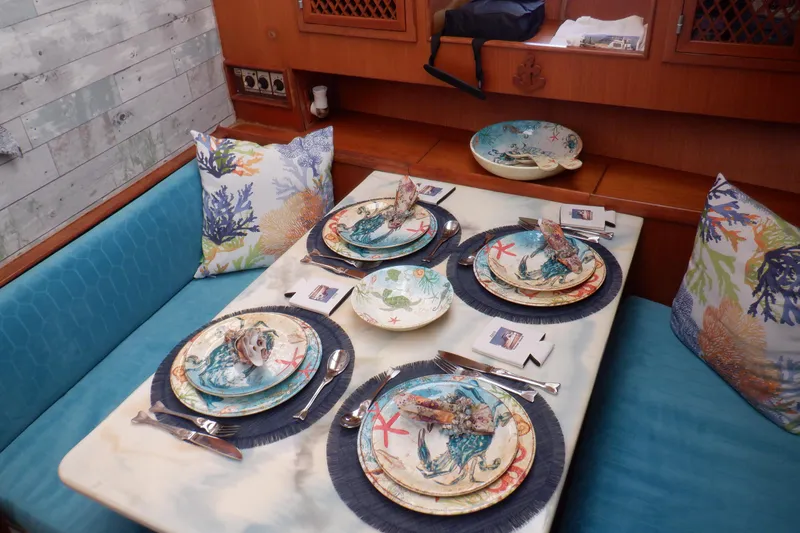 Slide: The Image of Dining area on 1990 Marine Trader 47 Tradewinds yacht with nautical-themed table setting. - 29