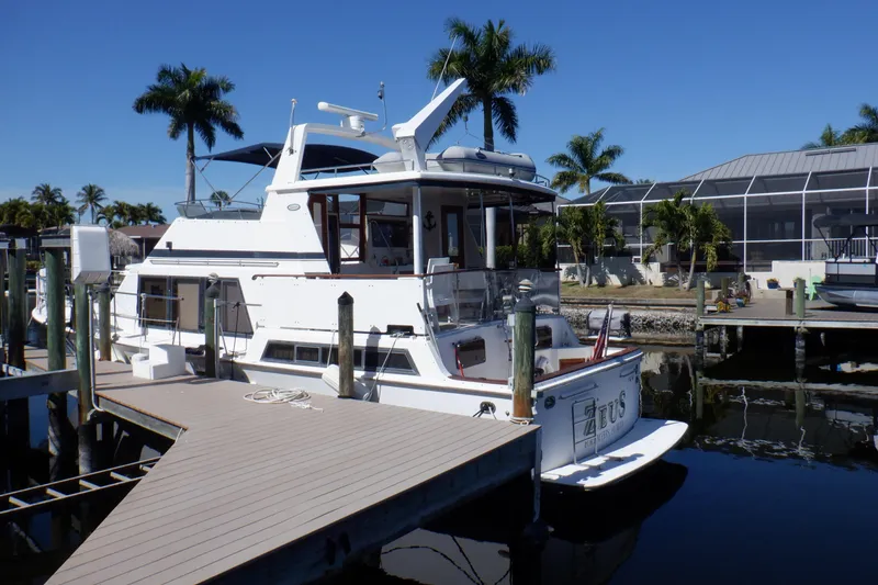 Slide: The Image of Marine Trader 47 Tradewinds yacht docked at marina, 1990 model, sunny day, palm trees. - 3
