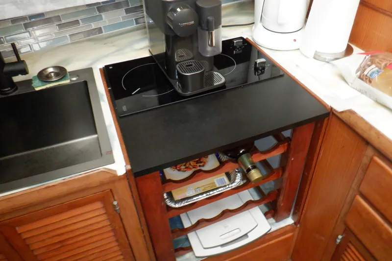 Slide: The Image of Compact kitchen area on 1990 Marine Trader 47 Tradewinds yacht with coffee maker and stove. - 31