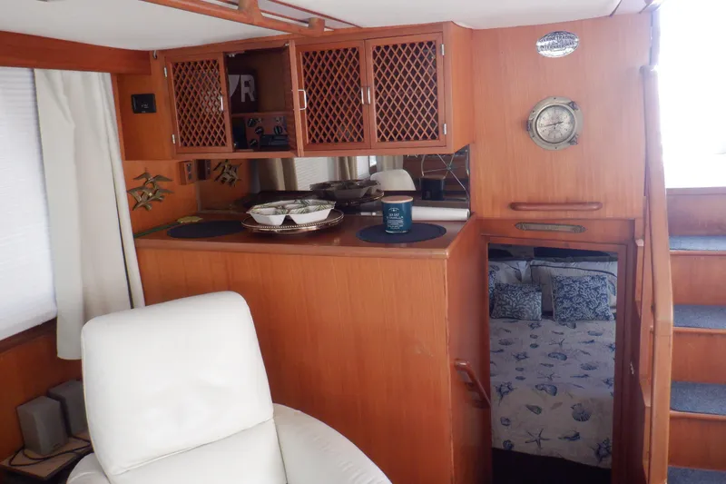 Slide: The Image of Interior of 1990 Marine Trader 47 Tradewinds yacht, featuring wood cabinetry and nautical decor. - 38