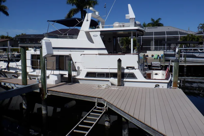 Slide: The Image of 1990 Marine Trader 47 Tradewinds yacht docked at marina under clear blue sky. - 4
