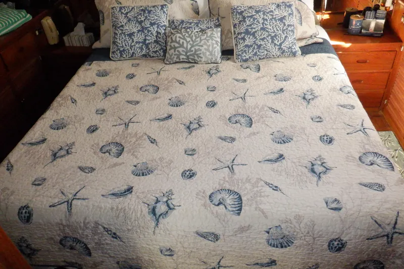 Slide: The Image of Nautical-themed bedding in Marine Trader 47 Tradewinds, 1990 model, with seashell and starfish patterns. - 41