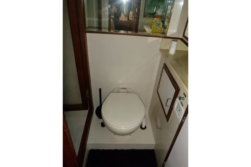 Slide: The Image of Marine Trader 47 Tradewinds 1990 yacht bathroom with toilet and storage cabinet. - 46
