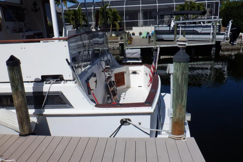 Slide: The Image of 1990 Marine Trader 47 Tradewinds yacht docked at a marina with American flag. - 5