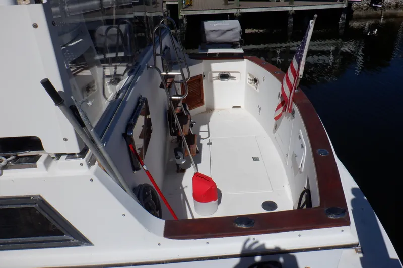 Slide: The Image of 1990 Marine Trader 47 Tradewinds yacht deck with American flag and dock view. - 6