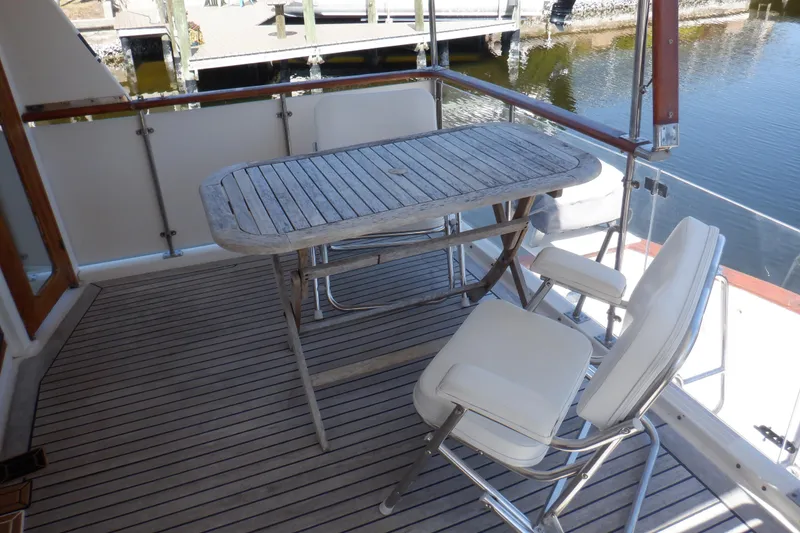 Slide: The Image of Outdoor seating on 1990 Marine Trader 47 Tradewinds yacht with wooden table and chairs. - 7