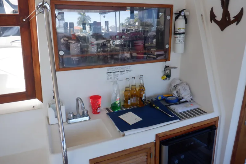 Slide: The Image of Marine Trader 47 Tradewinds 1990 yacht bar area with sink, drinks, and fire extinguisher. - 9