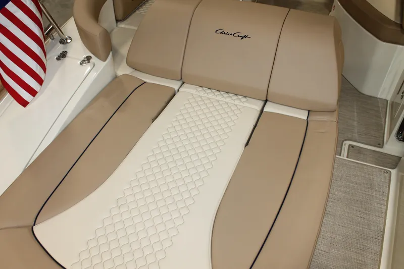 Slide: The Image of 2026 Chris-Craft Launch 28 GT boat interior with beige seating and American flag. - 27