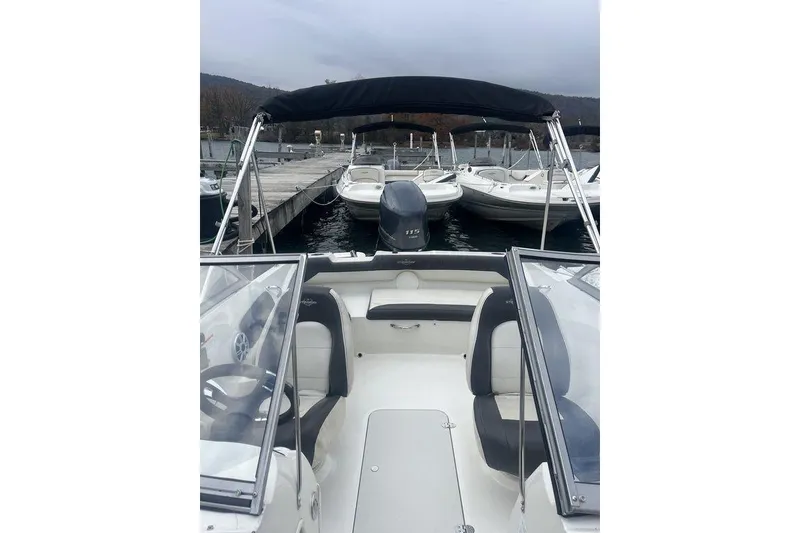 Slide: The Image of 2017 Stingray 191 DC boat with black canopy docked at marina. - 6