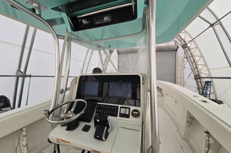 Slide: The Image of 2010 Jupiter 34 FS boat helm with dual screens and controls in covered storage. - 10